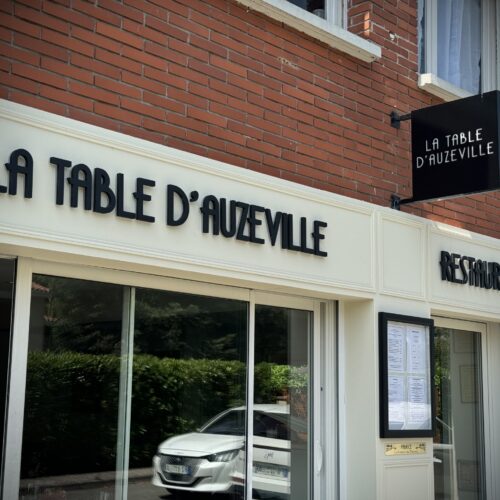 Enseigne lumineuse restaurant La Table d'Auzeville à Toulouse – vue de l'entrée avec panneau drapeau rétro-éclairé