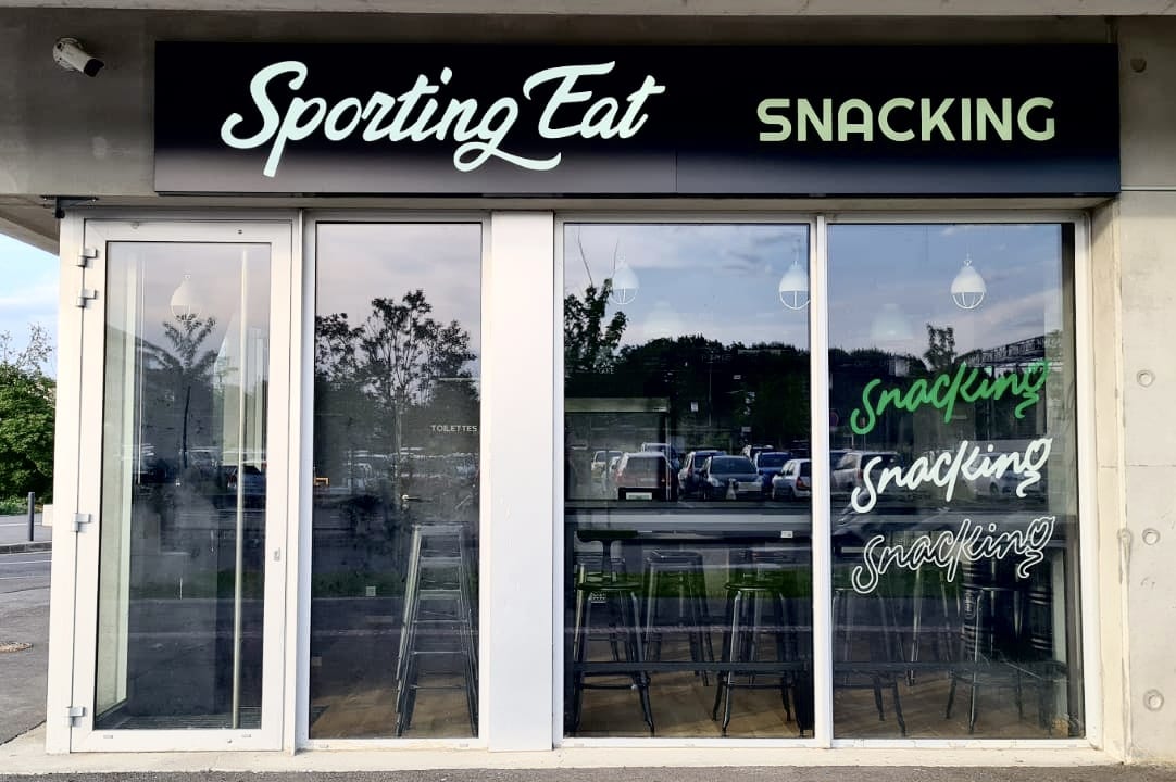 Façade du restaurant Sporting Eat à Toulouse avec enseigne lumineuse et vitrophanie
