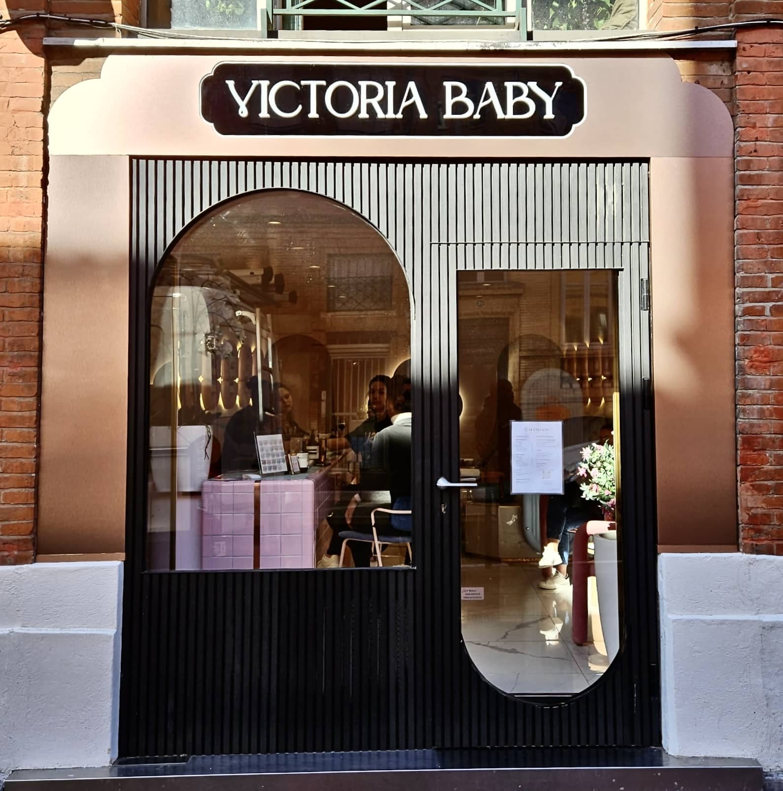 Façade de la boutique Victoria Baby à Toulouse avec enseigne lumineuse et porte arche design