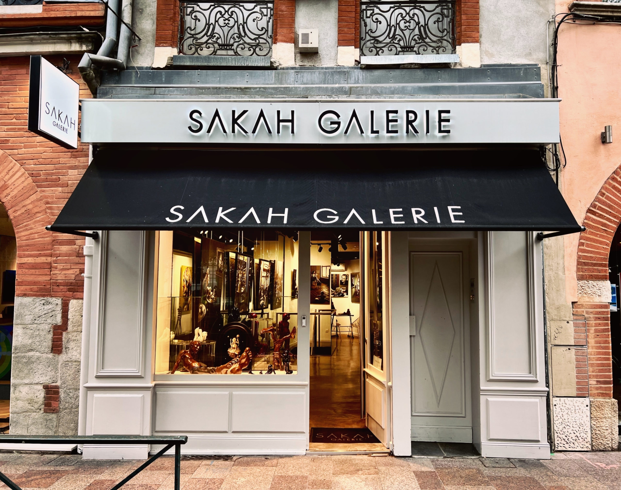 Façade de la boutique SAKAH GALERIE avec enseigne aluminium et store banne personnalisé noir