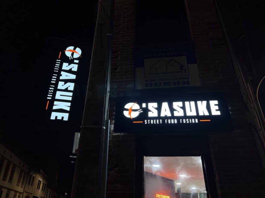 Façade du restaurant Sasuke Street Food à Toulouse avec enseigne lumineuse et enseigne drapeau