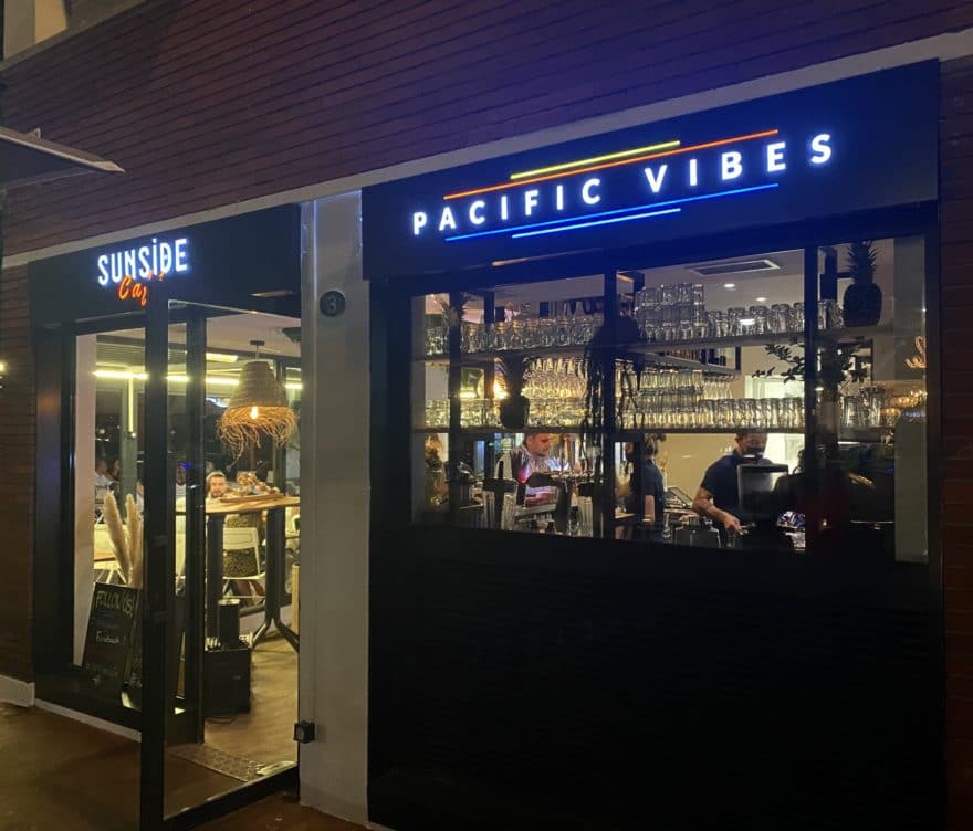 Façade du bar Pacific Vibes à Toulouse avec enseigne lumineuse multicolore de nuit