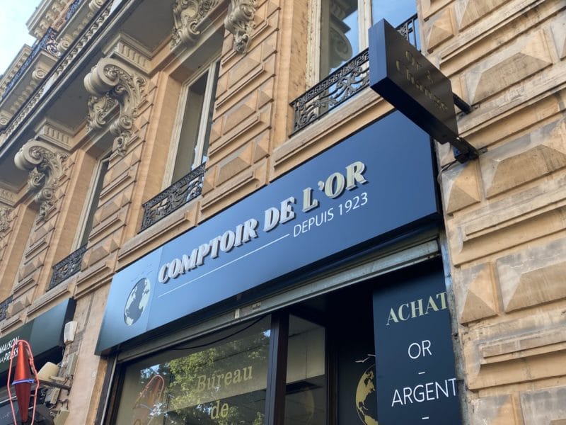 Façade du Comptoir de l’Or avec enseigne lumineuse et enseigne drapeau en centre-ville