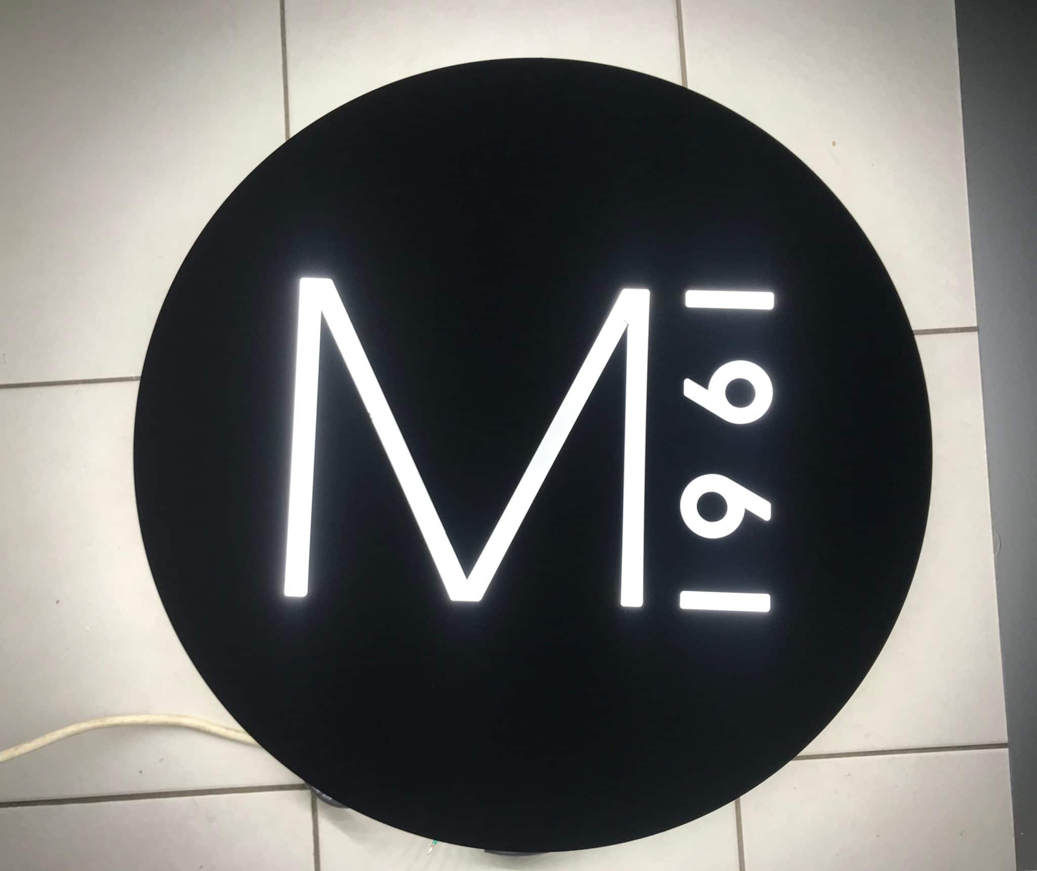 Enseigne lumineuse ronde M°1961 avec lettres blanches rétroéclairées sur fond noir