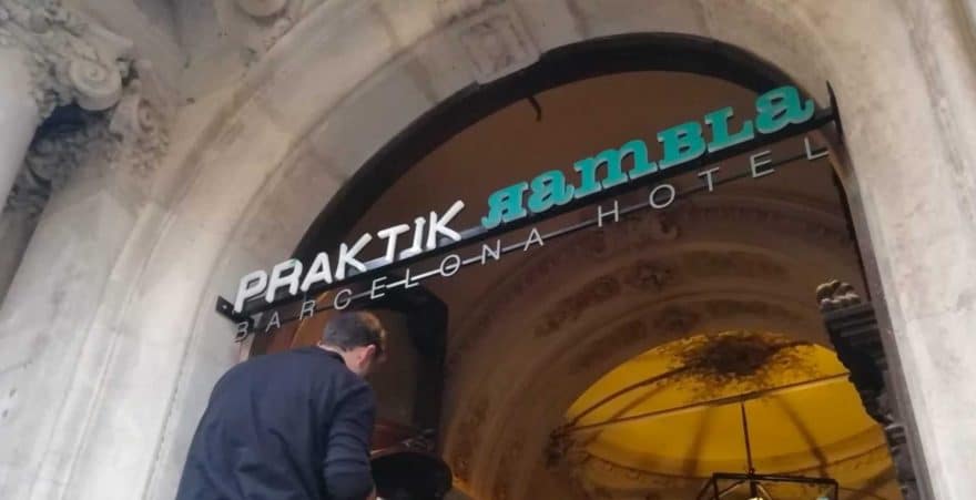 Enseigne Prak’tik Rambla avec lettres lumineuses installées sous arche en pierre