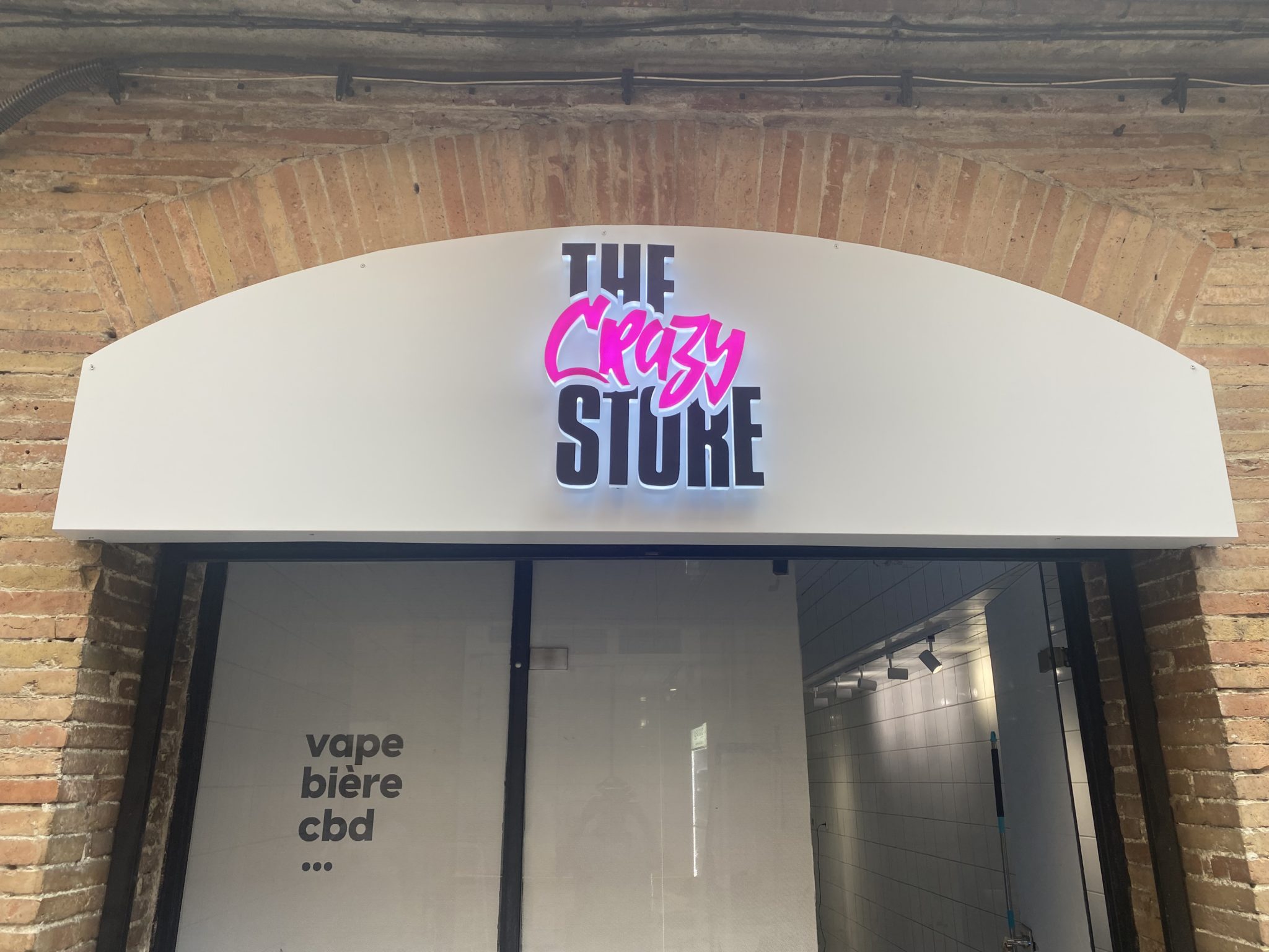Enseigne lumineuse The Crazy Store avec lettres LED rétroéclairées sur façade en arche