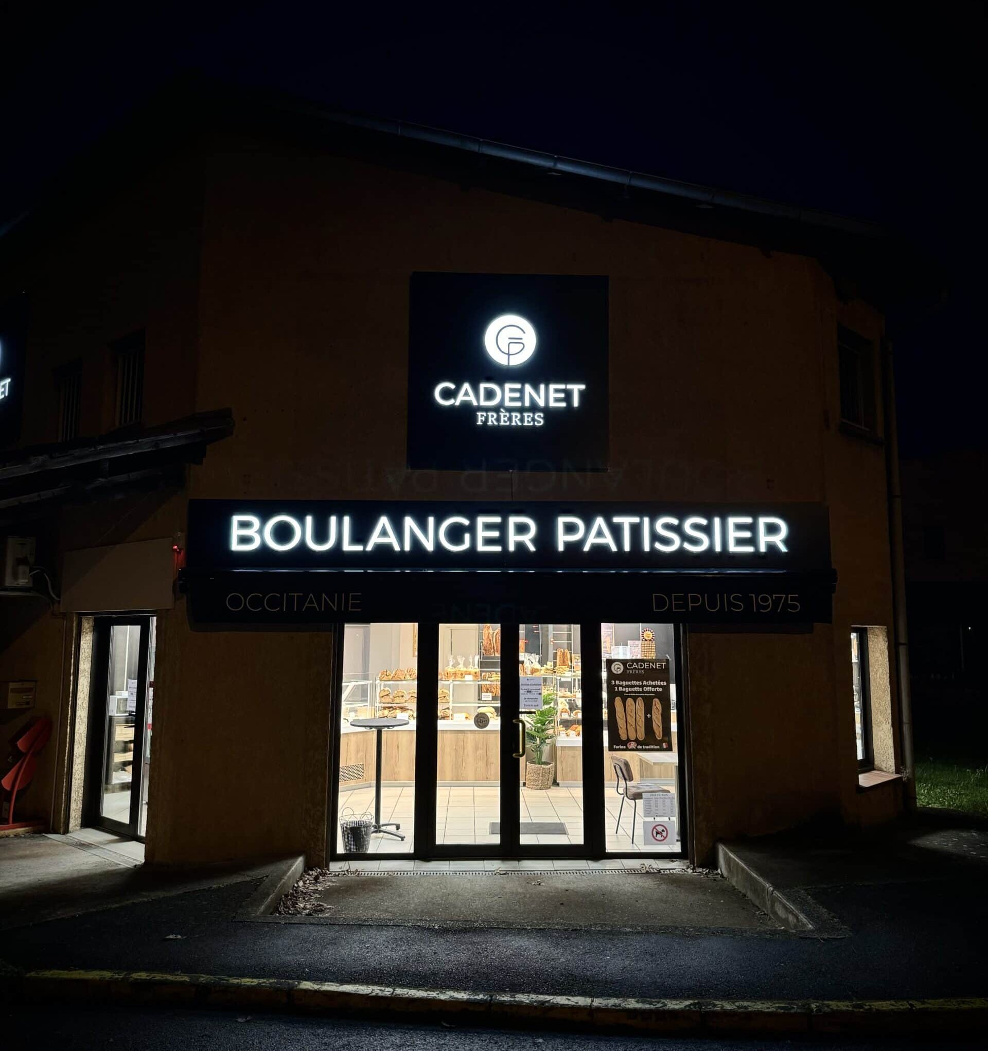 Façade de la boulangerie Cadenet Frères à Toulouse avec enseigne lumineuse de nuit