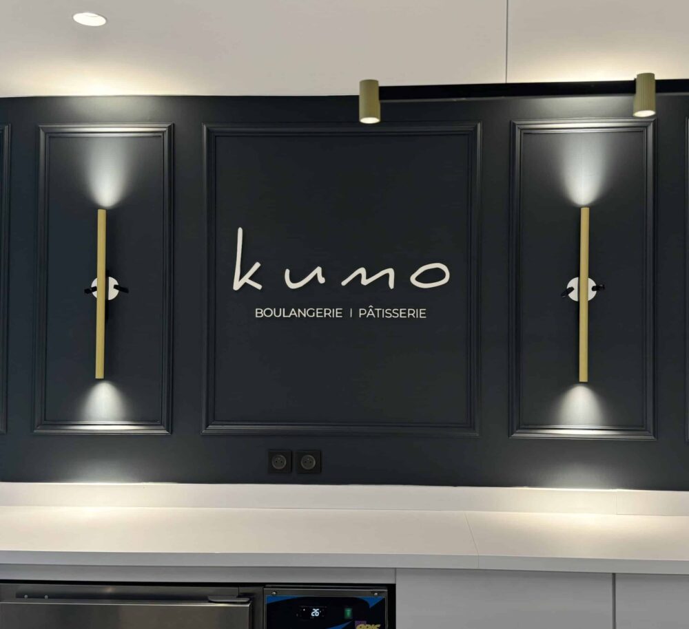 Mur décoratif noir avec logo Kumo en lettres élégantes et éclairage mural design à Toulouse