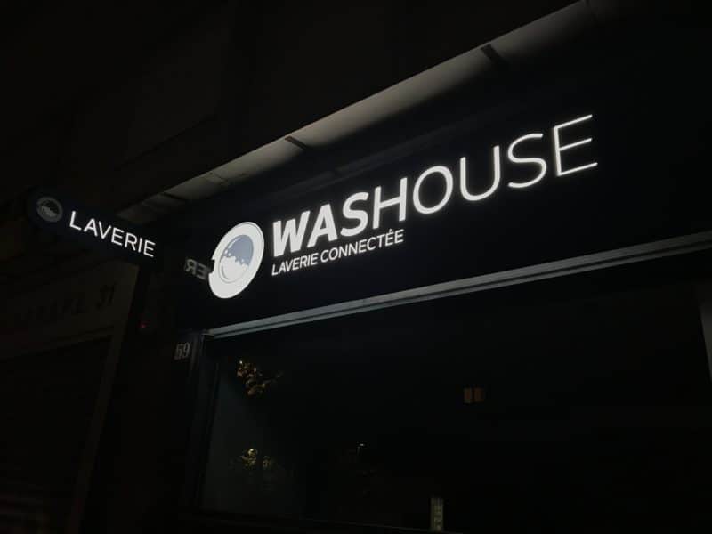 Façade de la laverie Washouse avec enseigne lumineuse et drapeau « Laverie »