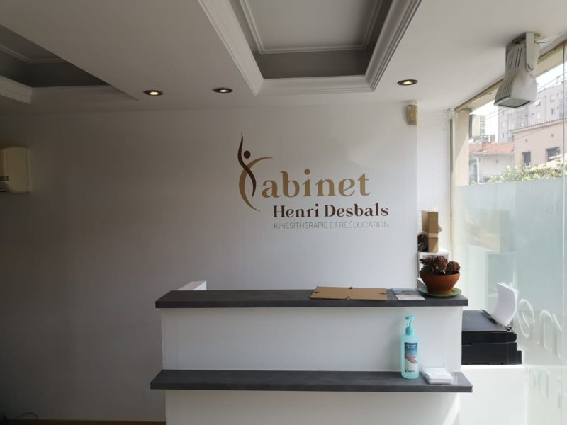 Accueil du cabinet Henri Desbals à Toulouse avec logo mural en lettres élégantes et comptoir moderne