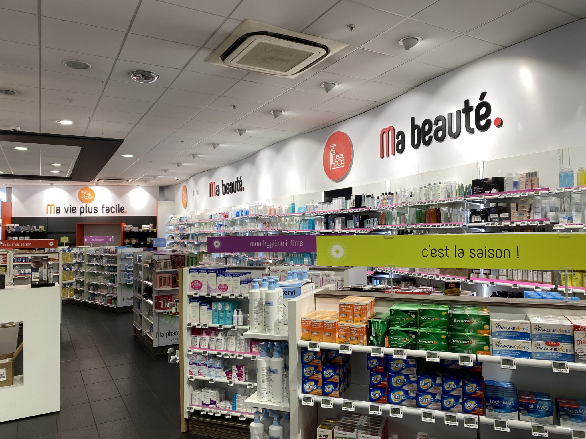 Rayon beauté d’une pharmacie à Toulouse avec signalétique murale « Ma beauté » et bandeaux suspendus thématiques