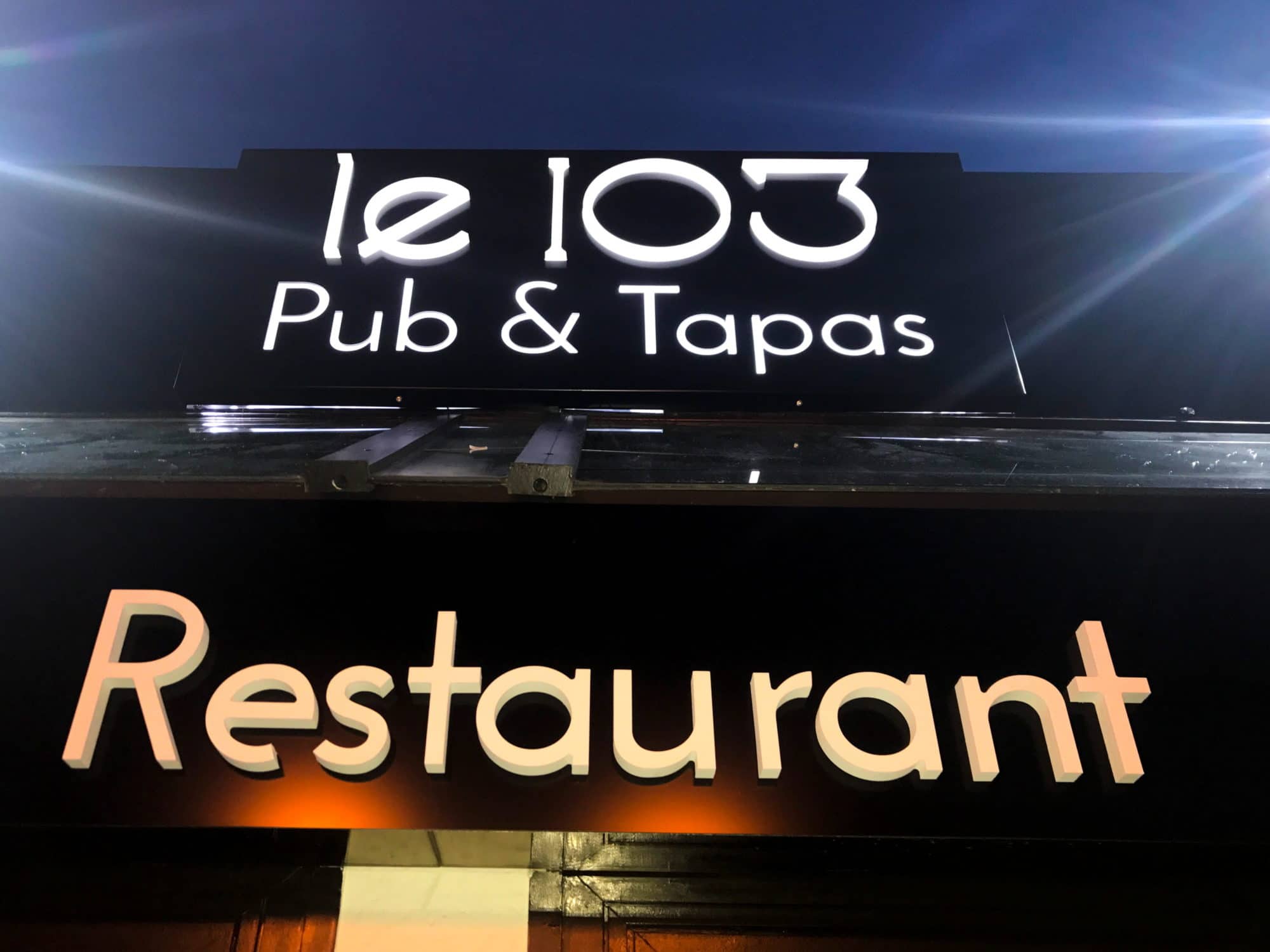 Enseigne lumineuse du restaurant Le 103 Pub & Tapas avec lettres LED blanches sur fond noir