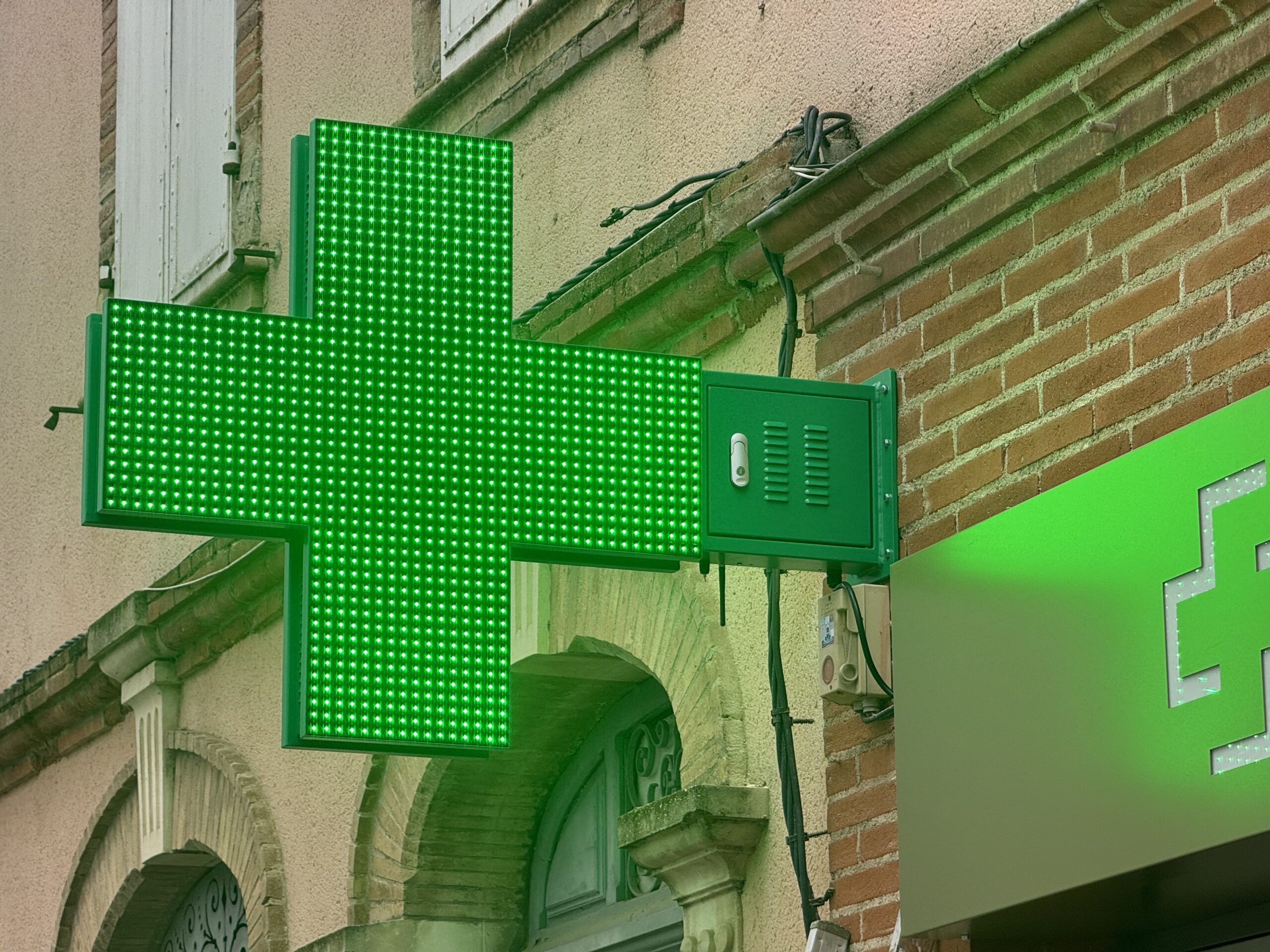 Croix de pharmacie LED verte haute luminosité installée en façade à Toulouse